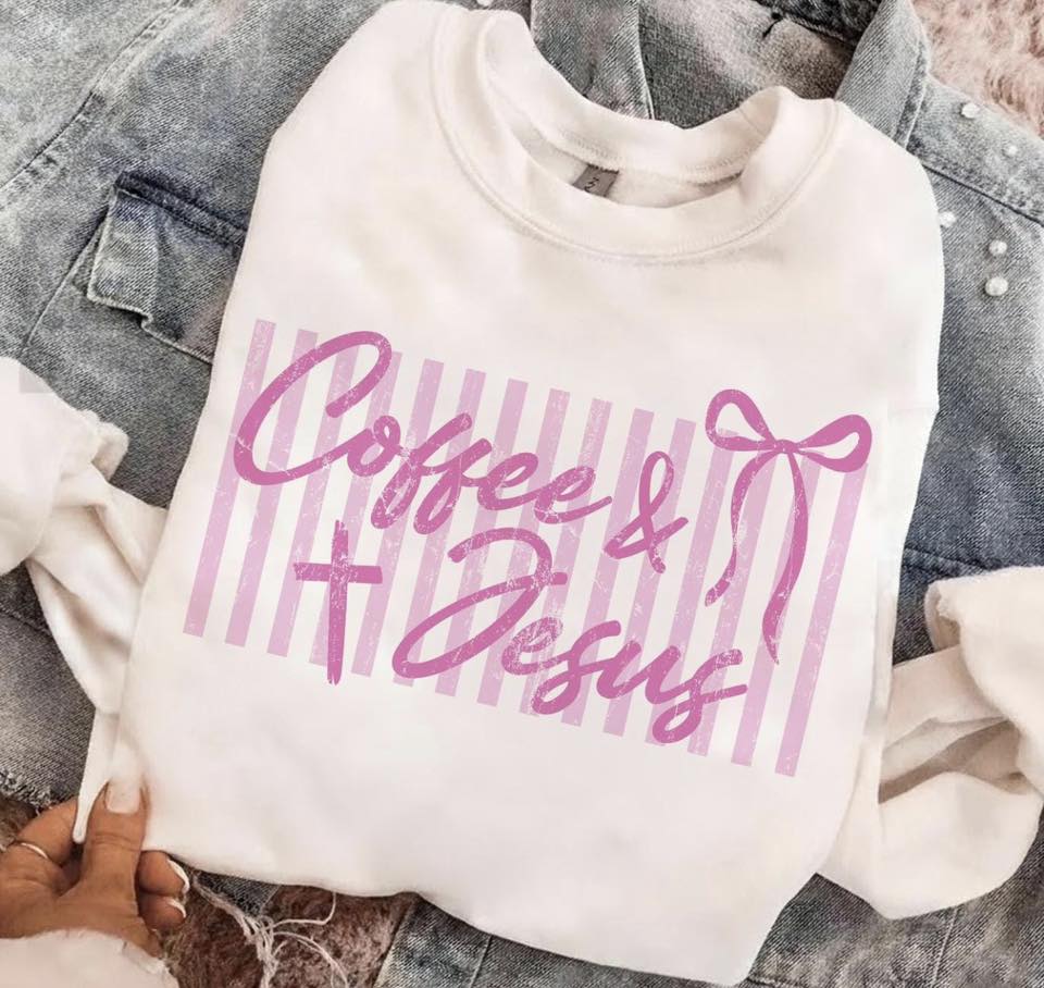 White sweatshirt with 'Coffee & Jesus' text in pink on a denim surface